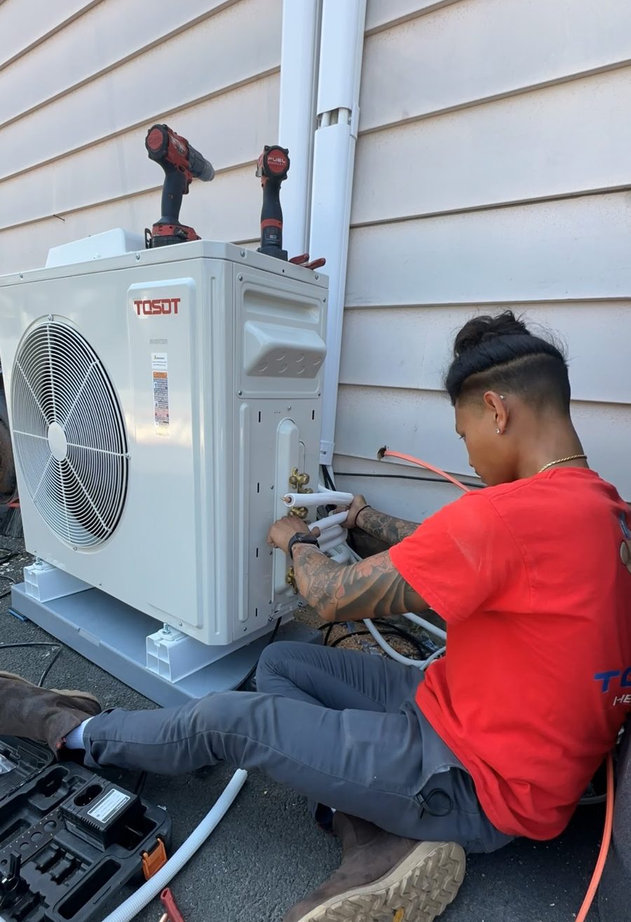 Topline technician connecting insulated refrigerant lines to a TOSOT ductless mini-split heat pump outdoor unit