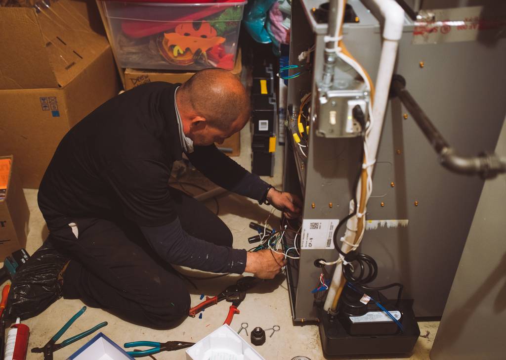 Topline technician wiring a newly installed gas furnace in a basement