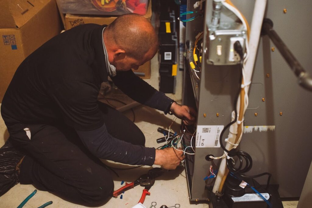 Topline technician wiring the controls on a new furnace during installation in a home basement